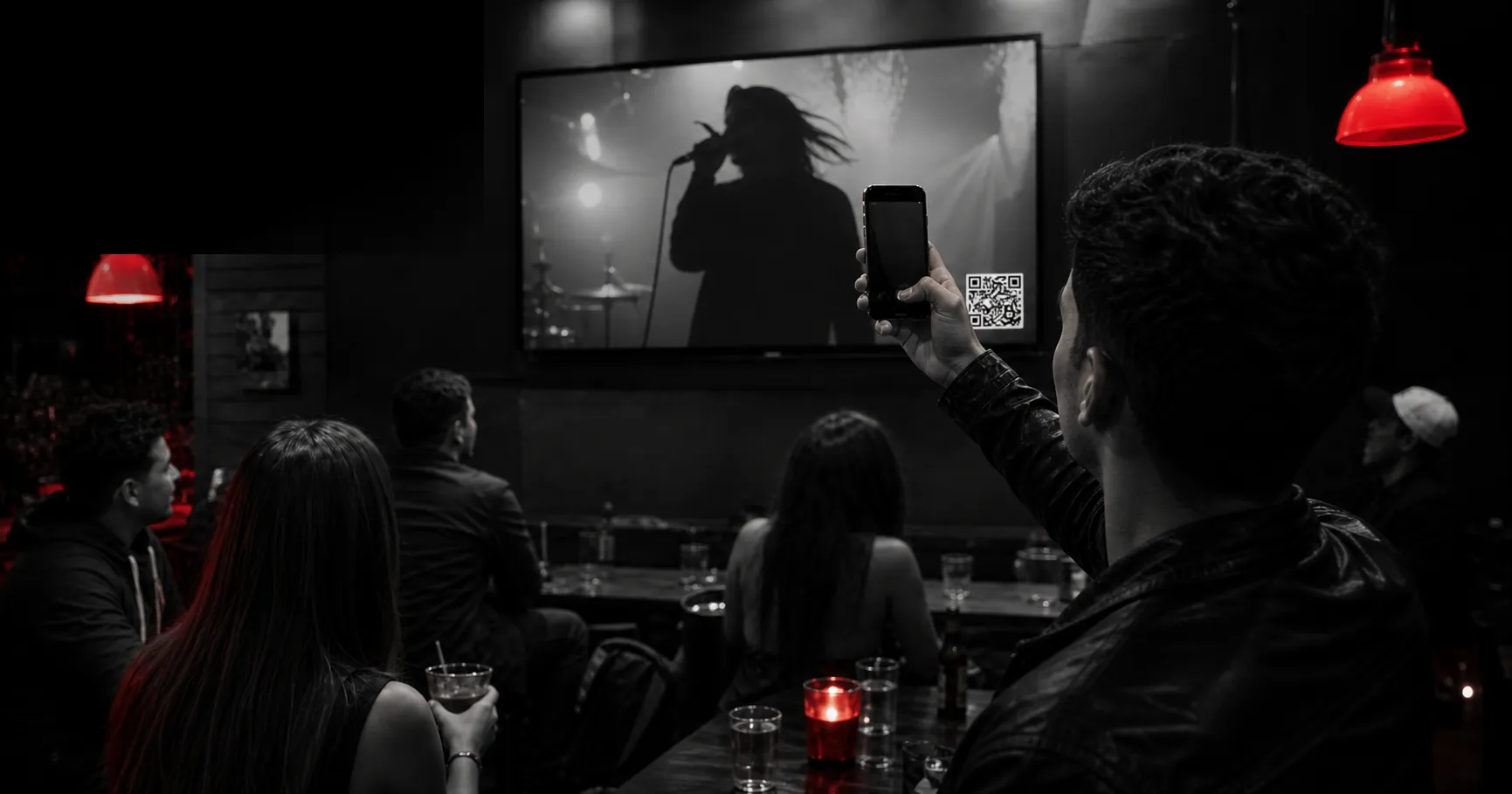 Cliente escaneando el QR de Repítela mostrado en el televisor de un bar