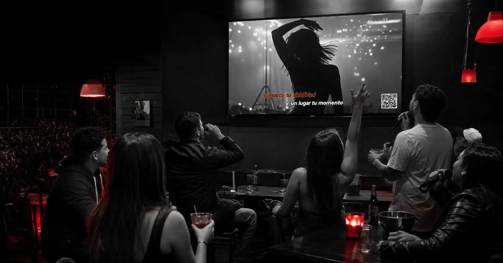 Clientes disfrutando una noche de karaoke con Repítela en un bar de Bogotá