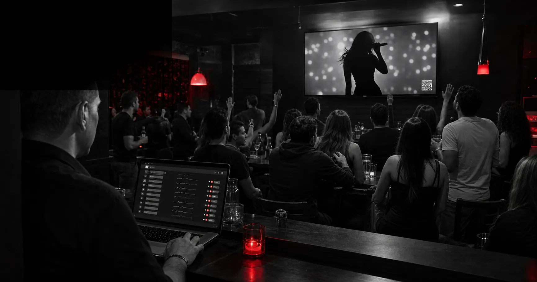 Administrador controlando Repítela mientras el público mira videos en una discoteca